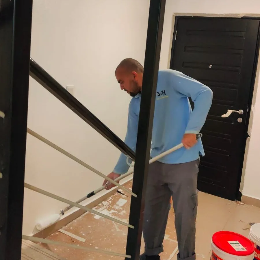 another professional expert is painting a wall by drill and hammer painting services in abu dhabi
